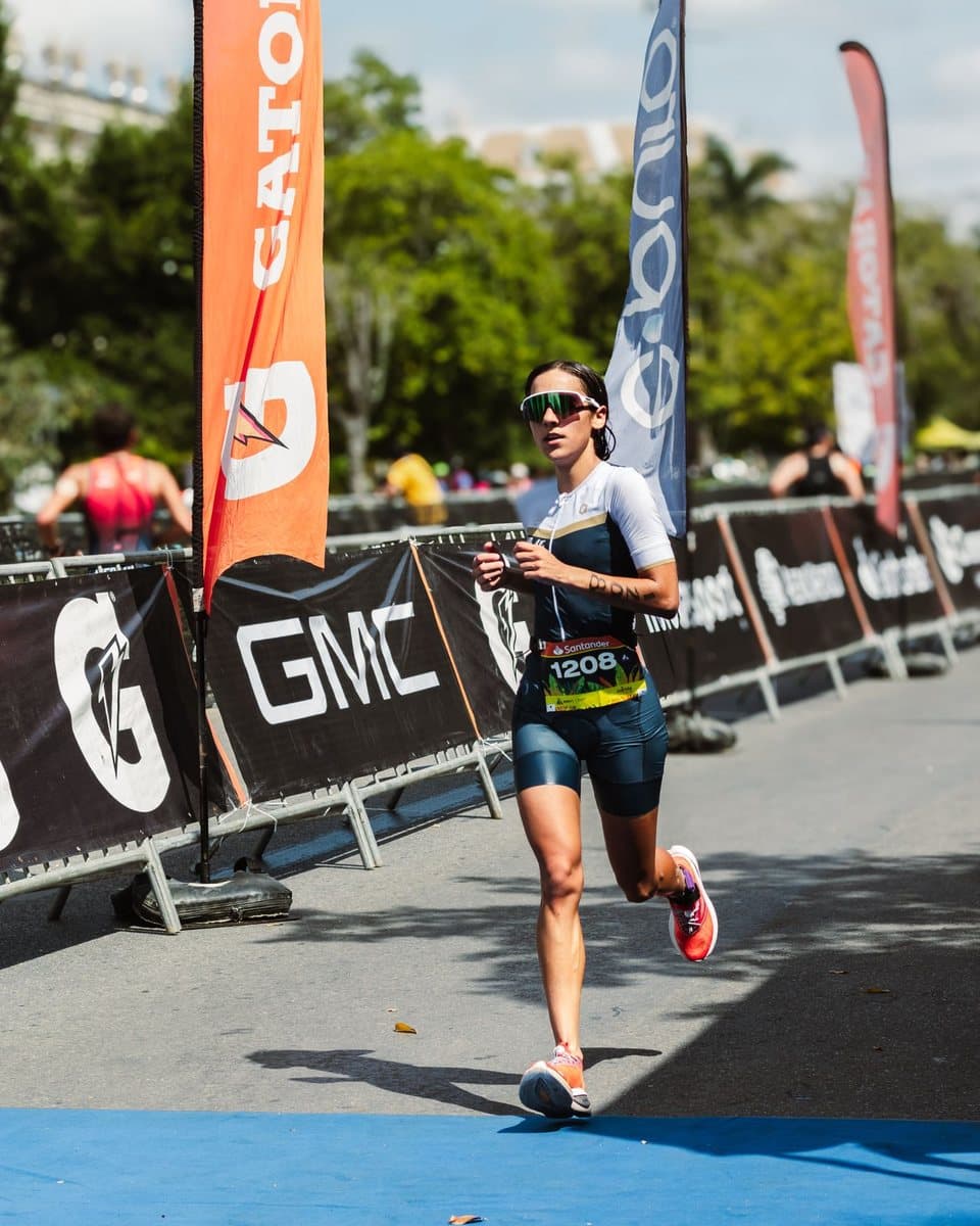 Triathlete running past a Gatorade flag and barrier
